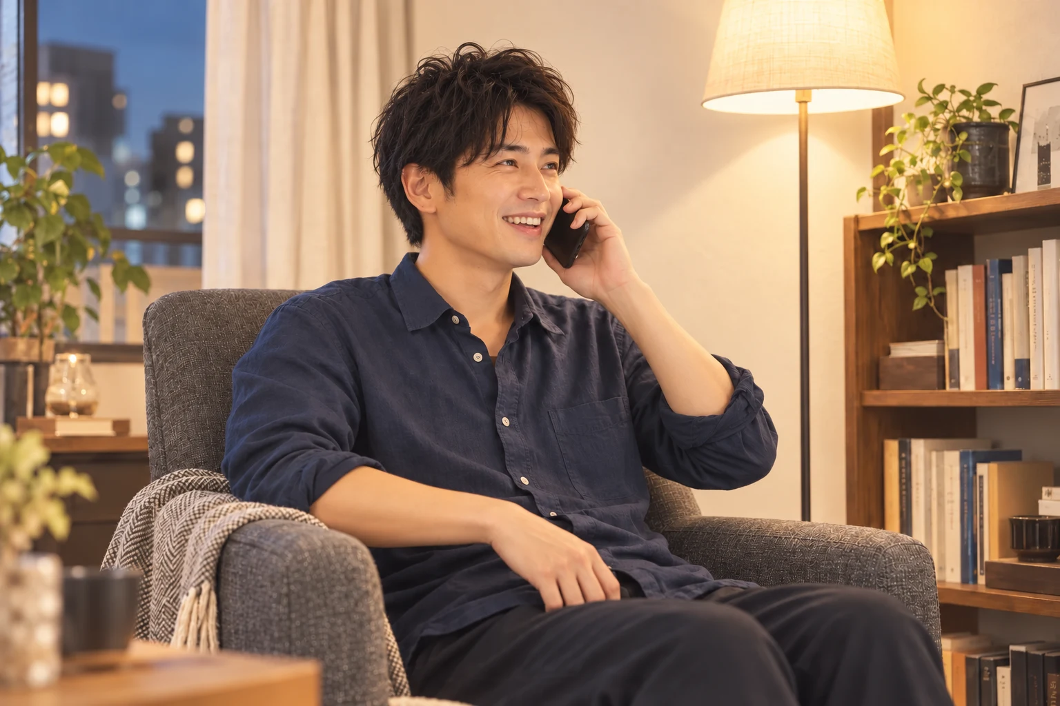 自分の部屋の椅子でスマートフォンを耳に当て、楽しそうに通話する男性。AI生成のイメージ
